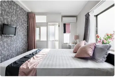 a bedroom with a large bed with a tv on the wall at Ikebukuro Florence Hostel in Tokyo