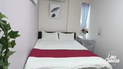 a bedroom with a bed with a red and white blanket at Ikebukuro Florence Hostel in Tokyo