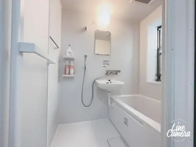 a white bathroom with a sink and a shower at Ikebukuro Florence Hostel in Tokyo