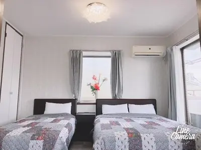 a bedroom with two beds and a window at Ikebukuro Florence Hostel in Tokyo