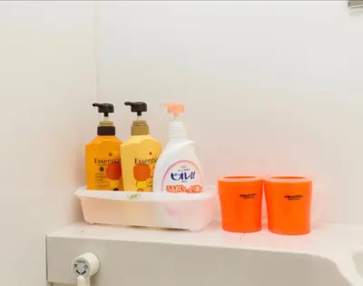a shelf with four bottles of detergent and two cups at Ikebukuro 706 in Tokyo