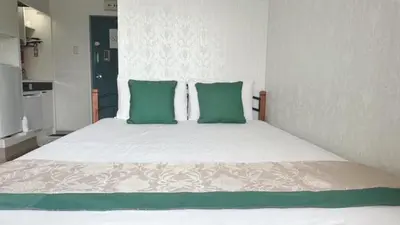 a bedroom with a large bed with green pillows at Ikebukuro 706 in Tokyo
