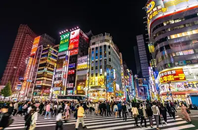 a crowd of people crossing a busy city street at night at \u30ec\u30b8\u30c7\u30f3\u30b7\u30e3\u30eb\u30b9\u30c6\u30fc\u30b8 in Tokyo
