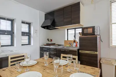 a kitchen with a wooden table with wine glasses on it at Good Space Hotel Yoyogi in Tokyo