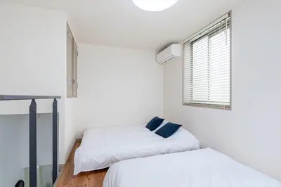 two beds in a small room with a window at Good Space Hotel Yoyogi in Tokyo