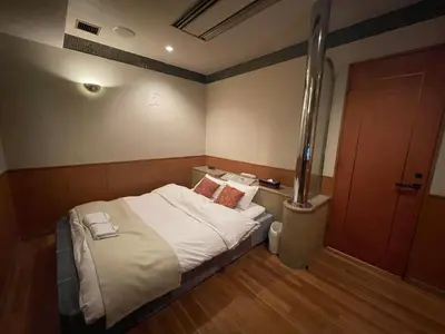 a small room with a bed and a wooden floor at Hotel Luxe - Adult Only in Tokyo