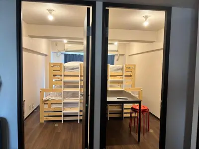 a room with a table and some bunk beds at Riverside Omori in Tokyo