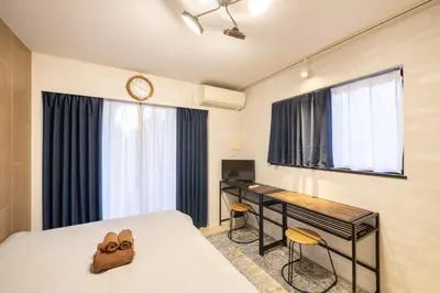 a bedroom with a bed and a desk and a clock at BO301 \u30ab\u30c3\u30d7\u30eb\u306b\u6700\u9069 \u6d45\u8349\u5bfa\u305d\u3070 \u65e5\u672c\u4ebaSuperHost in Tokyo