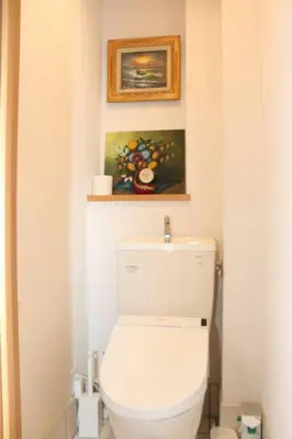 a bathroom with a toilet with a painting on the wall at RY-Whole \u6d45\u8349\u3067\u5bb6\u65cf\u65c5 2\u5bdd\u5ba42\u6d74\u5ba4\u306e\u4e00\u68df\u8cb8\u5207 \u65e5\u672c\u4ebaSuperHost in Tokyo