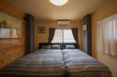 a bed in a bedroom with a large window at RY-Whole \u6d45\u8349\u3067\u5bb6\u65cf\u65c5 2\u5bdd\u5ba42\u6d74\u5ba4\u306e\u4e00\u68df\u8cb8\u5207 \u65e5\u672c\u4ebaSuperHost in Tokyo