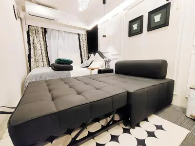 a bedroom with a large black bed in a room at Z97- Shinjuku center 5 mins to st ation ,\u65b0\u5bbf\u6700\u4e2d\u5fc3 \u6771\u65b0\u5bbf\u7ad95\u5206 in Tokyo