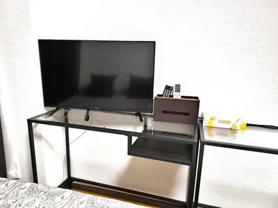 a flat screen tv sitting on a glass table at T Stay in Tokyo