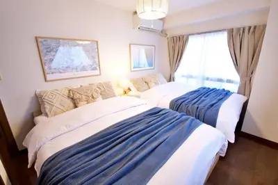 two beds in a room with a window at NH building5F in Tokyo