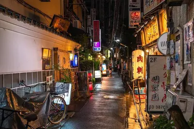 a narrow street at night with signs on buildings at NH building5F in Tokyo