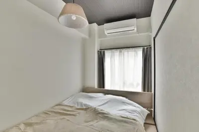 a small bedroom with a bed and a window at \u5ca1\u7530\u30d3\u30eb5\u968e in Tokyo