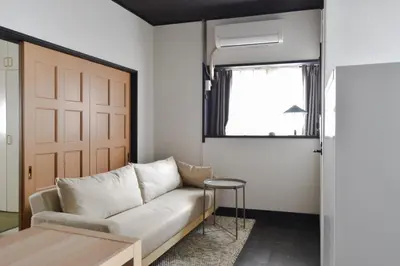 a living room with a couch and a window at \u5ca1\u7530\u30d3\u30eb5\u968e in Tokyo