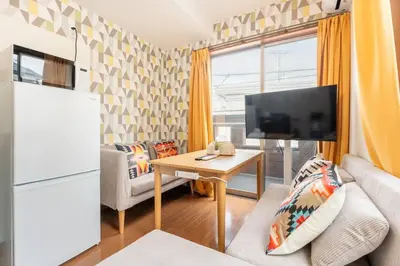 a living room with a couch and a tv and a table at \u30a2\u30f3\u30c9\u30b9\u30c6\u30a4\u5fd7\u83025\u4e01\u76ee in Tokyo