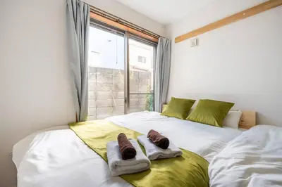 a bedroom with two beds with towels on them at \u30a2\u30f3\u30c9\u30b9\u30c6\u30a4\u5fd7\u83025\u4e01\u76ee in Tokyo