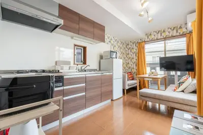 a kitchen with a stove top oven next to a living room at \u30a2\u30f3\u30c9\u30b9\u30c6\u30a4\u5fd7\u83025\u4e01\u76ee in Tokyo