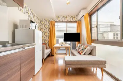 a kitchen and living room with a couch and a tv at \u30a2\u30f3\u30c9\u30b9\u30c6\u30a4\u5fd7\u83025\u4e01\u76ee in Tokyo