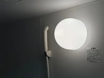 a bathroom with a mirror and a light on the wall at \u65b0\u5bbf\u795e\u697d\u5742\u8fd1\u304f\u5bff\u53f8\u5e972 in Tokyo