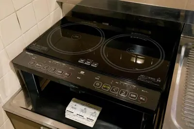 a black stove top oven sitting in a kitchen at ALDO INN Kitasenju 3F in Tokyo