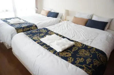 two beds in a room with towels on them at ALDO INN Kitasenju 3F in Tokyo