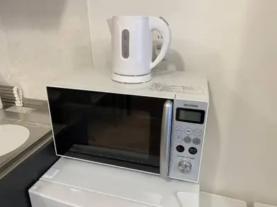 a coffee pot sitting on top of a microwave at Musashi's hotel IKEBUKURO2F in Tokyo