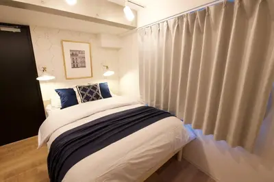 a bedroom with a bed and a window with curtains at Musashi's hotel IKEBUKURO2F in Tokyo