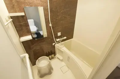 a small bathroom with a toilet and a tub at Musashi's hotel IKEBUKURO2F in Tokyo