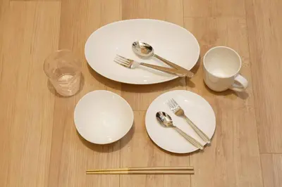 three white plates and forks and a cup on a table at Musashi's hotel IKEBUKURO2F in Tokyo