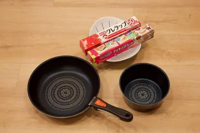 two frying pans on a wooden table with some snacks at Musashi's hotel IKEBUKURO2F in Tokyo
