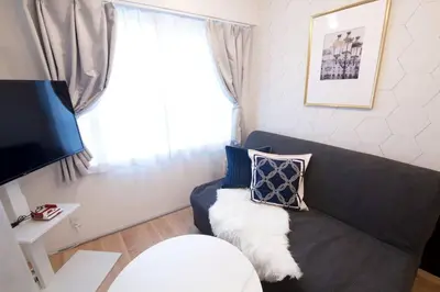 a living room with a gray couch and a window at Musashi's hotel IKEBUKURO2F in Tokyo