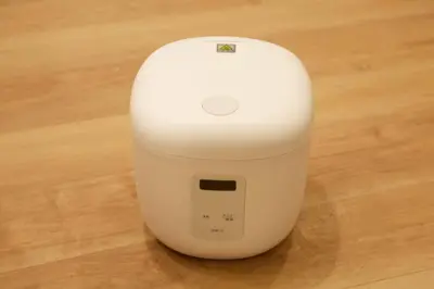 a white computer mouse sitting on a wooden floor at \u30b6\u30fb\u30b8\u30a7\u30df\u30cb\u30b9\u6c60\u888b101 in Tokyo