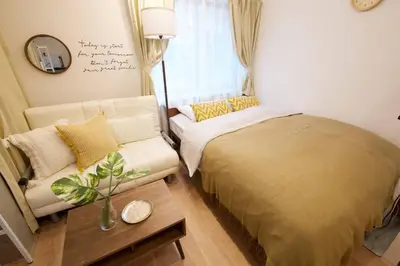 a small bedroom with a bed and a couch at \u30b6\u30fb\u30b8\u30a7\u30df\u30cb\u30b9\u6c60\u888b101 in Tokyo