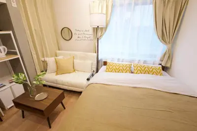 a living room with a bed and a couch at \u30b6\u30fb\u30b8\u30a7\u30df\u30cb\u30b9\u6c60\u888b101 in Tokyo