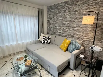 a living room with a couch and a brick wall at Relax House in Tokyo