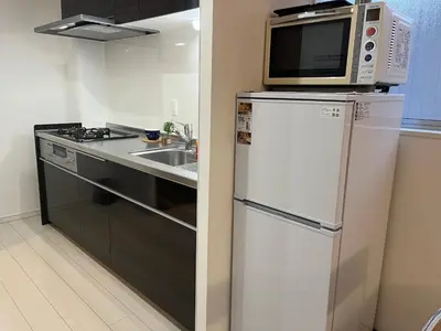 a kitchen with a microwave on top of a refrigerator at Relax House in Tokyo