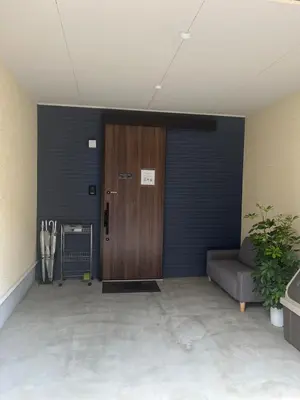 a lobby with a wooden door and a couch at Relax House in Tokyo