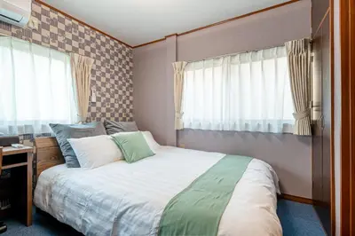 a bedroom with a large bed and a window at Sharil Nishi-Shinjuku in Tokyo