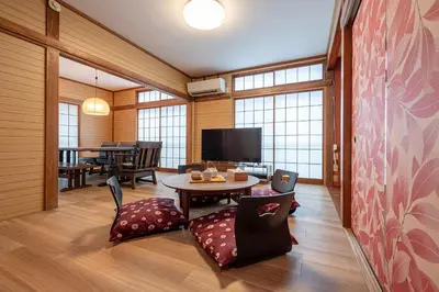 a room with a table and chairs and a tv at Sharil Nishi-Shinjuku in Tokyo
