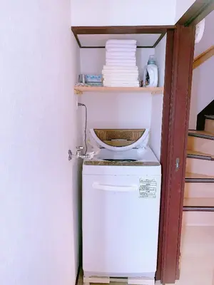 a small refrigerator with a stack of plates on a shelf at miki II in Tokyo