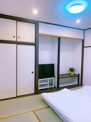 a bedroom with a bed and a flat screen tv at miki II in Tokyo