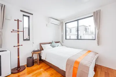 a white bedroom with a bed and a window at Ikebukuro Shopping Street 3BR in Tokyo
