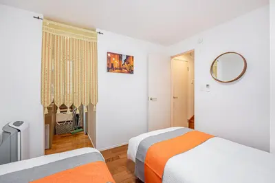 a white bedroom with two beds and a mirror at Ikebukuro Shopping Street 3BR in Tokyo