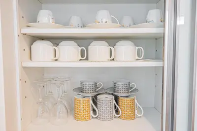 a cupboard filled with lots of dishes and cups at Ikebukuro Shopping Street 3BR in Tokyo