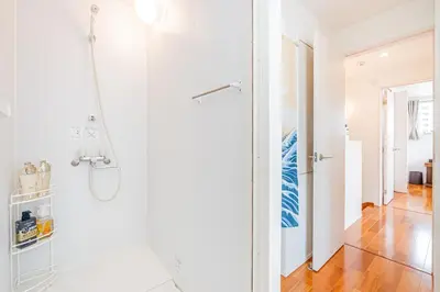 a white bathroom with a shower with a glass door at Ikebukuro Shopping Street 3BR in Tokyo