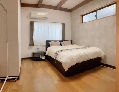 a bedroom with a large bed with a window at Guesthouse cherry in Tokyo