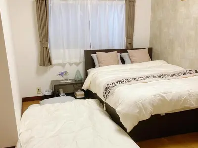 two beds sitting next to each other in a bedroom at Guesthouse cherry in Tokyo