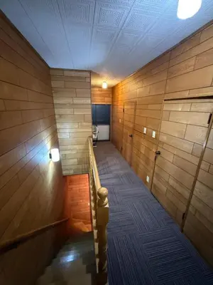 a hallway with wooden walls and stairs in a room at Guesthouse cherry in Tokyo